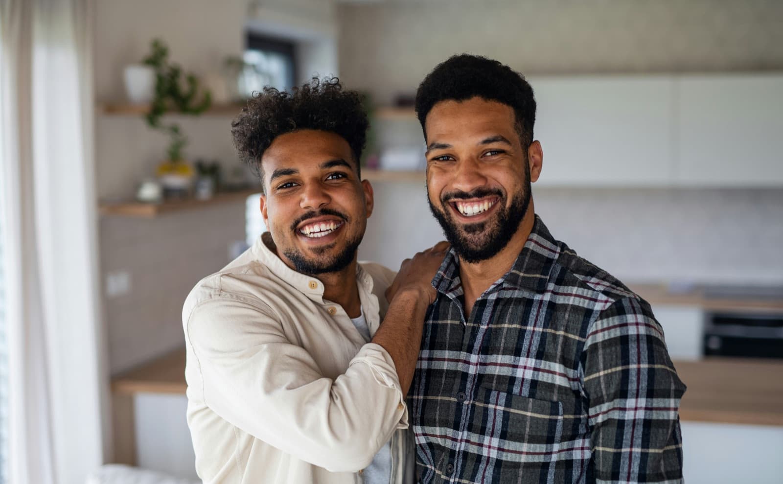 Two friends laughing together at home